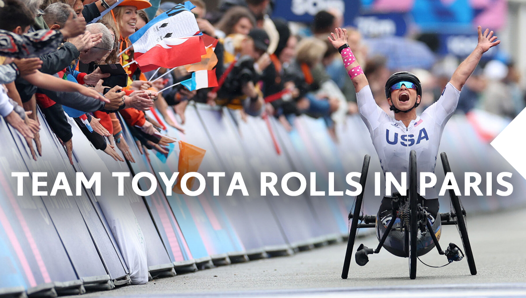 Team Toyota athlete raises hands after finishing race